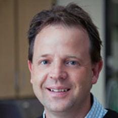 Close-up of a smiling middle-aged man with short brown hair.
