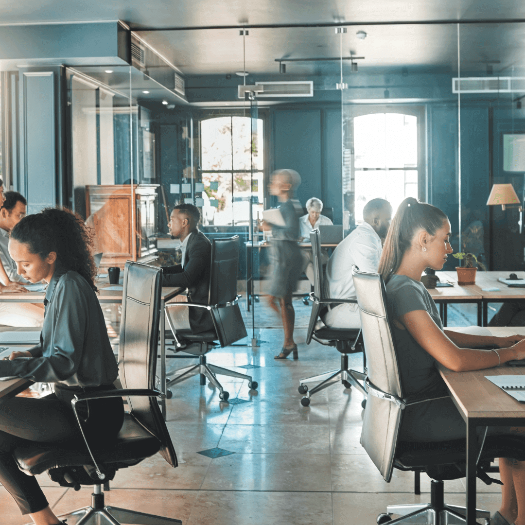 Busy office with people working at desks.
