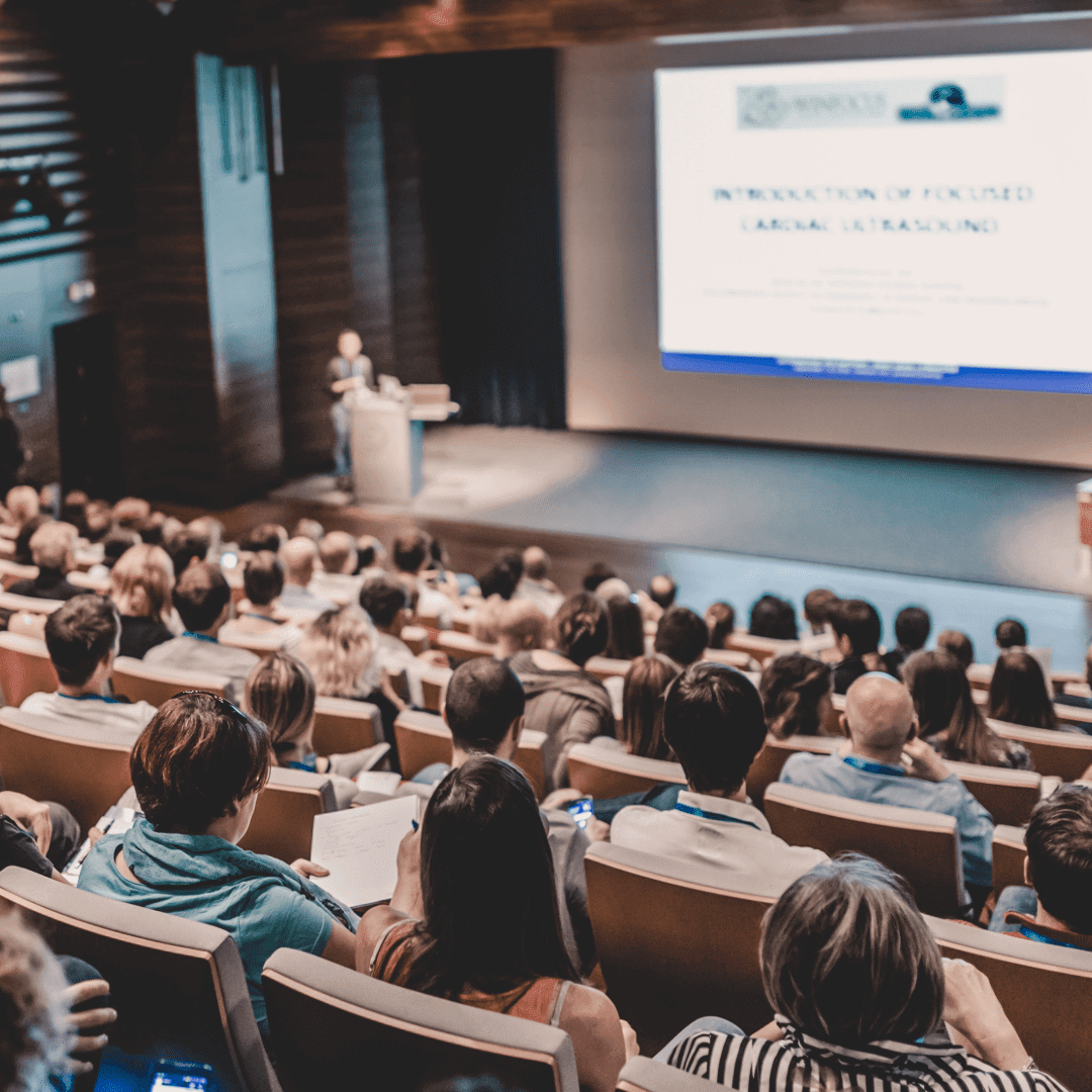 Audience attending a presentation in auditorium.
